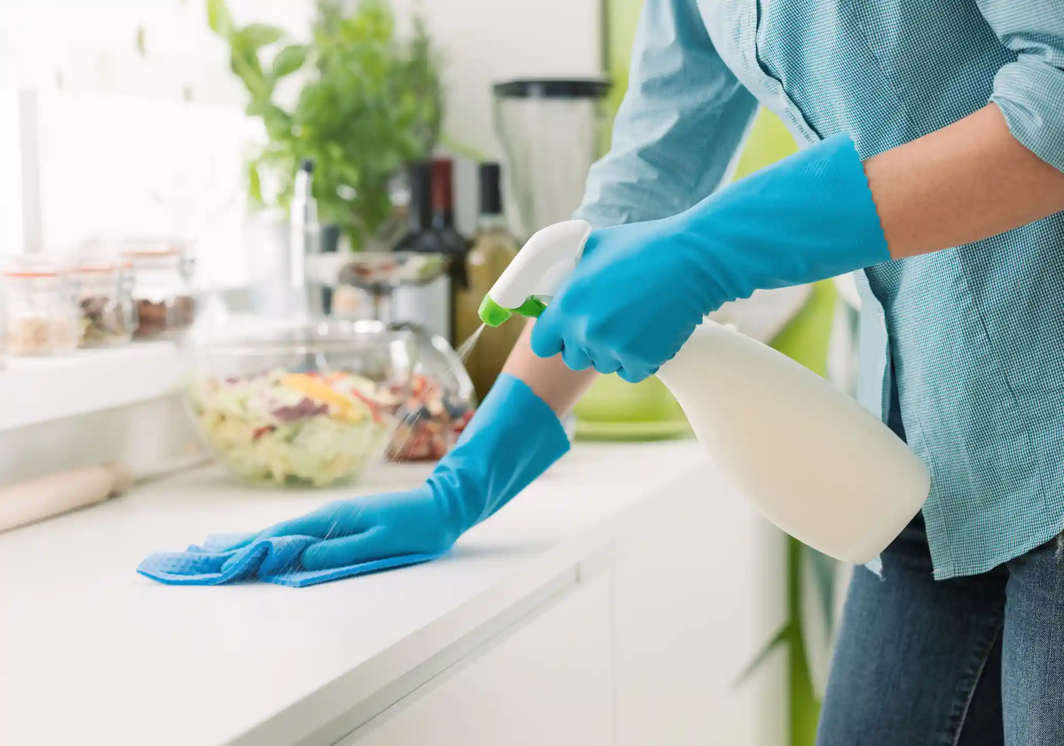 woman wiping down kitchen counter