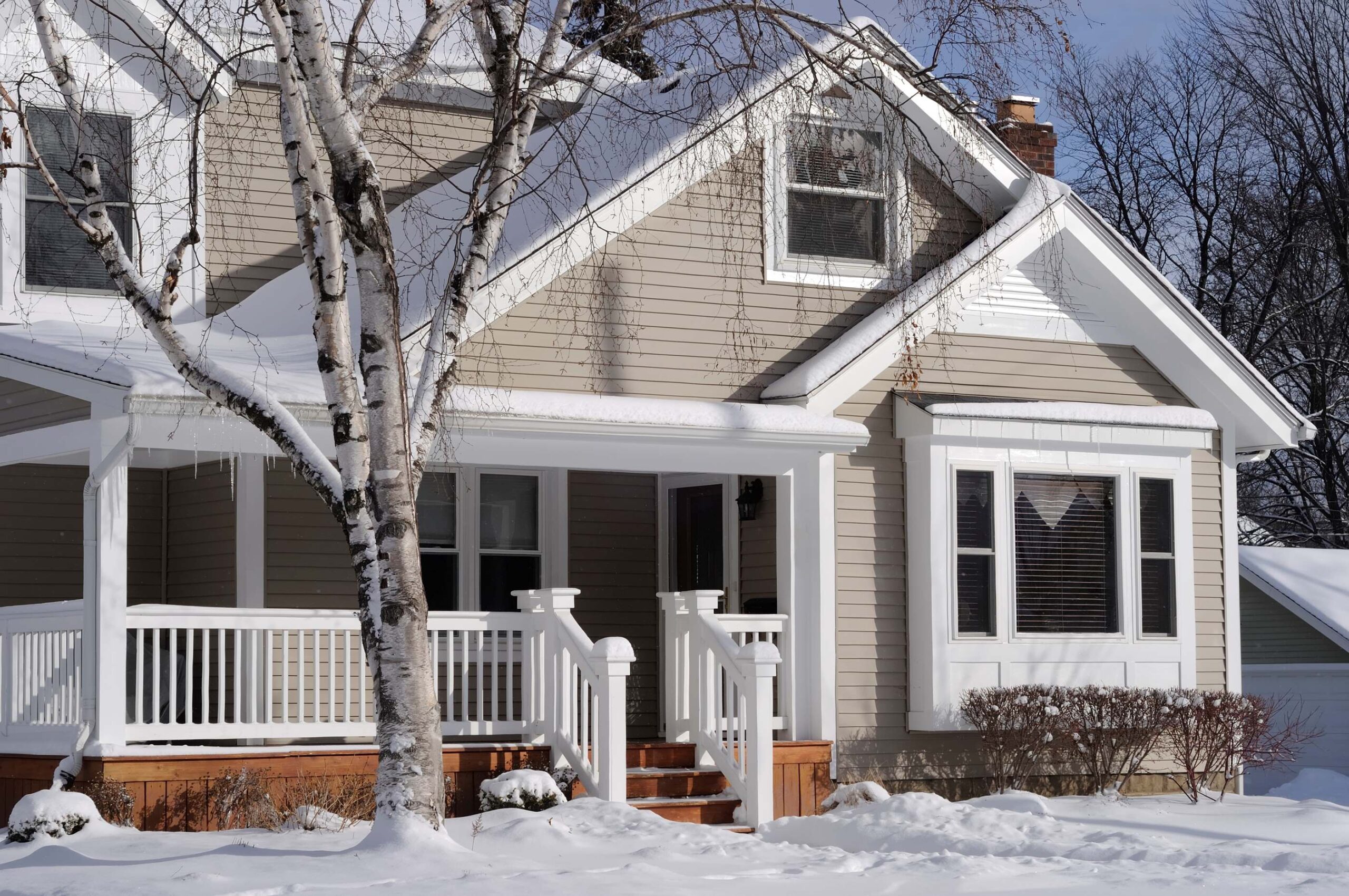 A midwestern home covered in snow and ice in the winter.